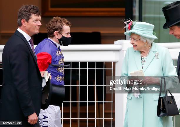 Trainer Andrew Balding and jockey Ryan Moore talk with Queen Elizabeth II in the parade ring before riding her horse 'King's Lynn' in the Wokingham...