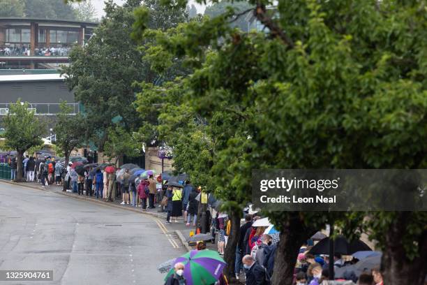 Tennis fans queue to enter the Wimbledon All England Tennis Club ahead of day one of the Wimbledon tennis championships on June 27, 2021 in...