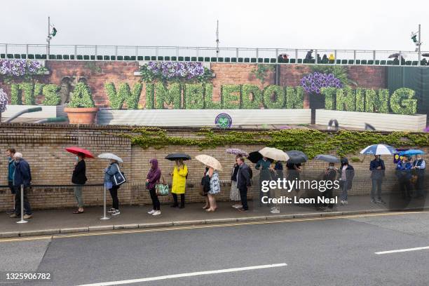 Tennis fans queue to enter the Wimbledon All England Tennis Club ahead of day one of the Wimbledon tennis championships on June 27, 2021 in...