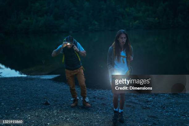couple walking with flashlights - flashlight stock pictures, royalty-free photos & images
