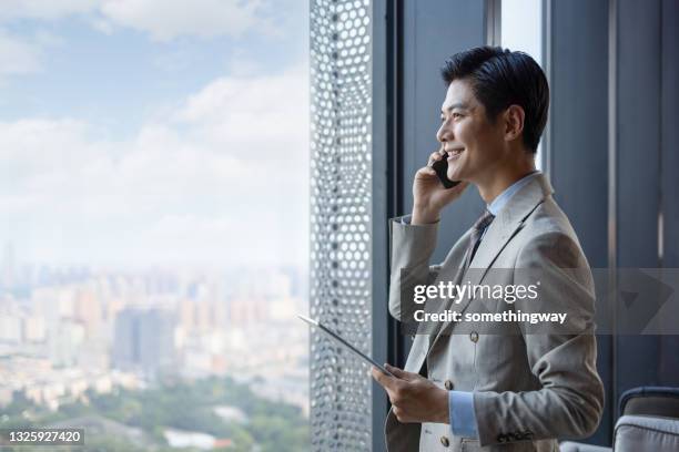 asian businessmen using mobile phones - asian businessman happy stock pictures, royalty-free photos & images