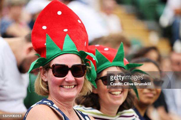 Fans look on wearing strawberry themed hats during Day One of The Championships - Wimbledon 2021 at All England Lawn Tennis and Croquet Club on June...
