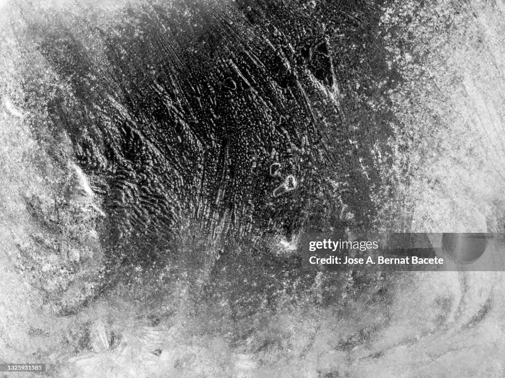 Full frame of an outdoor semi-transparent smooth ice surface.