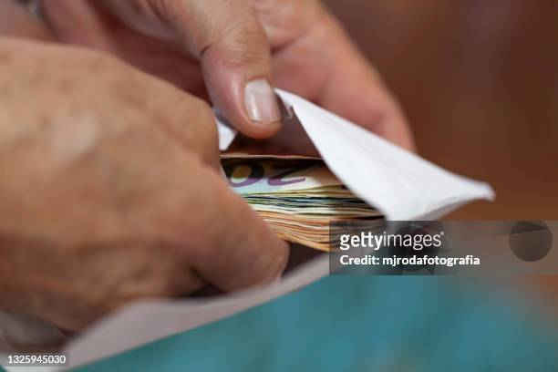 putting money in an envelope - 貪污 個照片及圖片檔