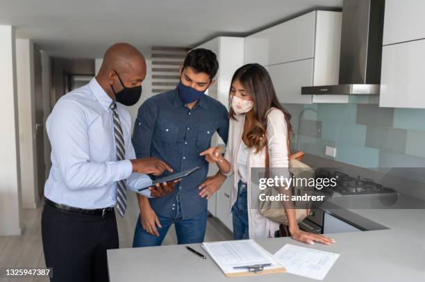 real estate agent showing a couple a house for sale during the pandemic - tenant stock pictures, royalty-free photos & images