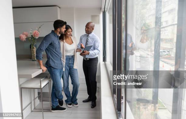agente de bienes raíces hablando con una pareja que compra un apartamento - salesman fotografías e imágenes de stock