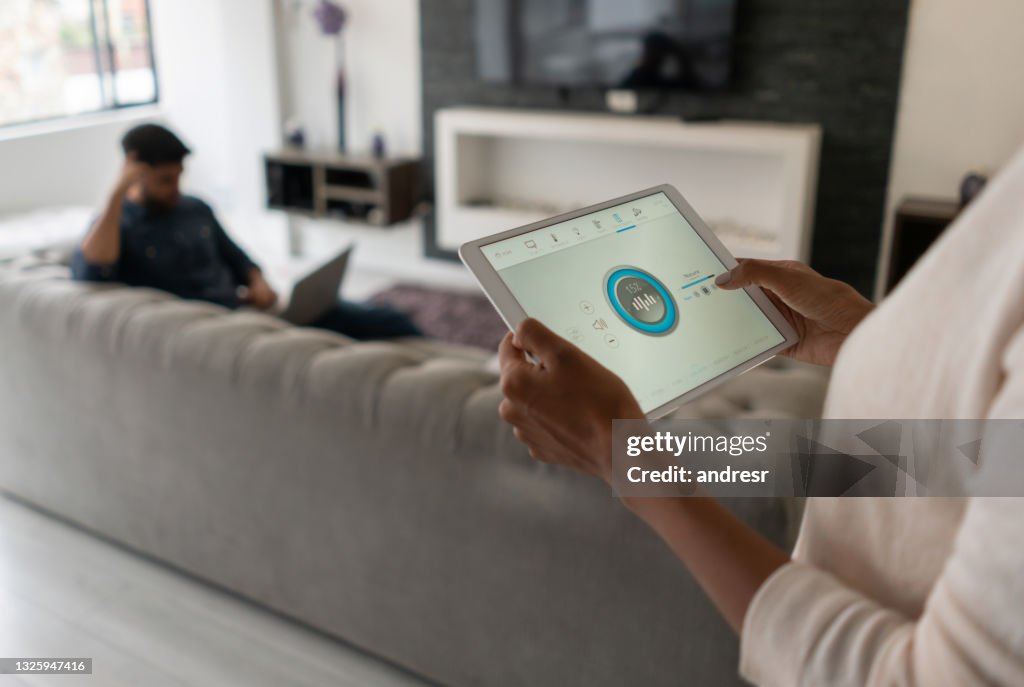 Woman living in a smart home and controlling the music from her tablet computer