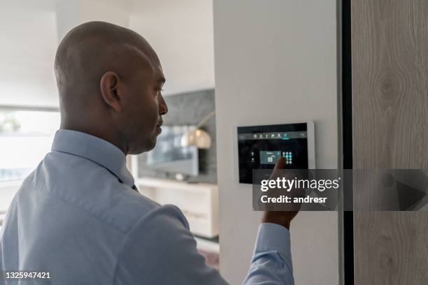 real estate agent locking the door of a house using a home automation system - security home bildbanksfoton och bilder