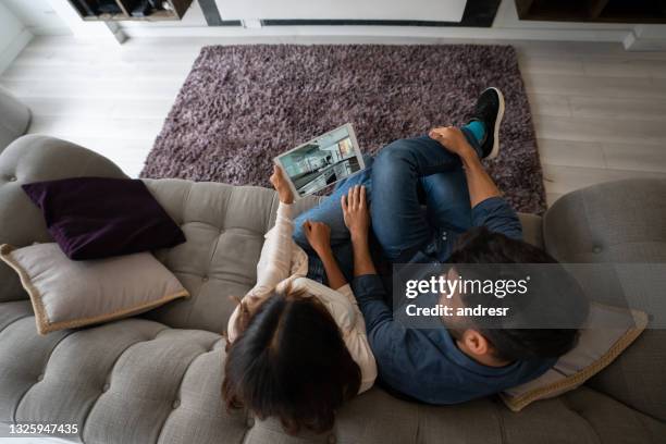 couple on a video call with their real estate agent and taking a virtual tour of a house for sale - mass tourism imagens e fotografias de stock