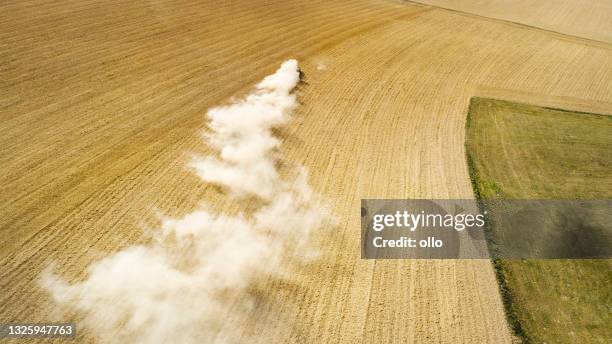 tractor, harrow and dust on an agricultural field - aerial view - field stubble stock pictures, royalty-free photos & images