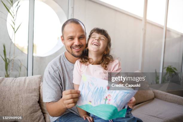 happy father and daughter showing her home made card to the camera - i love you card stock pictures, royalty-free photos & images