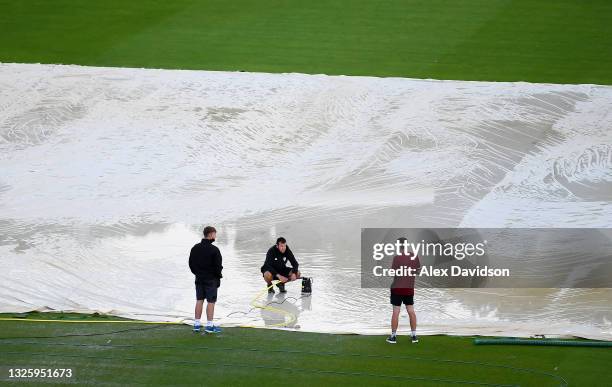 Groundstaff work on the covers as play is delayed due to rain in the Vitality T20 Blast Match between Hampshire and Middlesex at the Ageas Bowl on...