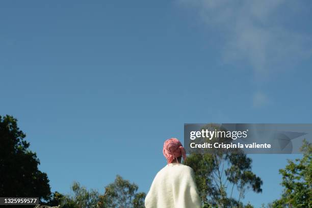 silhouette of woman with a pink scarf on her head, has cancer with sky and trees background - levend organisme stockfoto's en -beelden