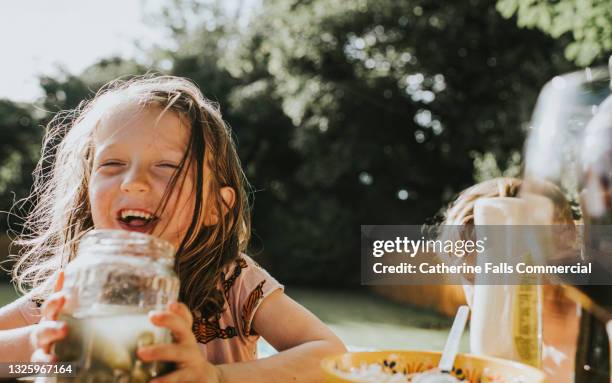 a joyful child holds a jar of pickled gherkins - essiggurke stock-fotos und bilder