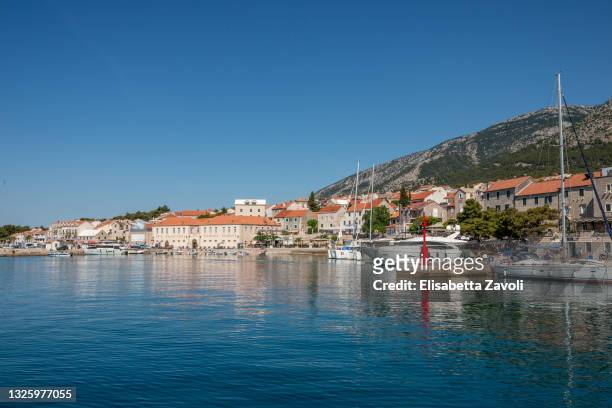 The town stretches between high dry land and a crystal clear blue sea on June 28, 2021 in Bol, Croatia. The wine cellar building is the longest one...
