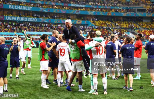 Vladimir Petkovic, Head Coach of Switzerland is lifted up by Breel Embolo of Switzerland following victory in the penalty shoot out after the UEFA...