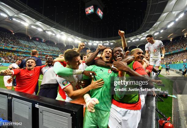 Yann Sommer and Denis Zakaria of Switzerland celebrate with team mates after their side's victory in the penalty shoot out after the UEFA Euro 2020...