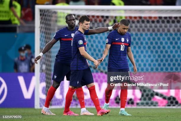 Kylian Mbappe of France is consoled by teammates Moussa Sissoko and Benjamin Pavard after taking the decisive penalty that was saved by Yann Sommer...