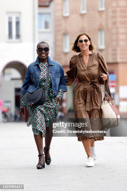 Auma Obama wearing a brown and mint green midi length longsleeve dress with abstract floral pattern and tied waist by Odeeh, a blue denim jeans...