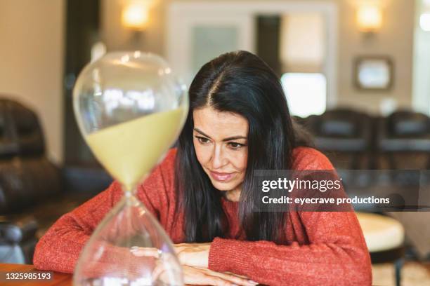 femmina adulta matura di etnia ispanica guardando l'ora serie fotografica di vetro serie fotografica - simbolo concettuale foto e immagini stock