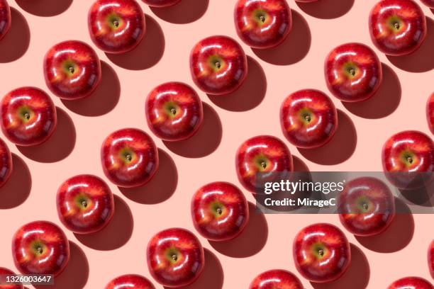 arranged red apples repetition on light red - replica foto e immagini stock