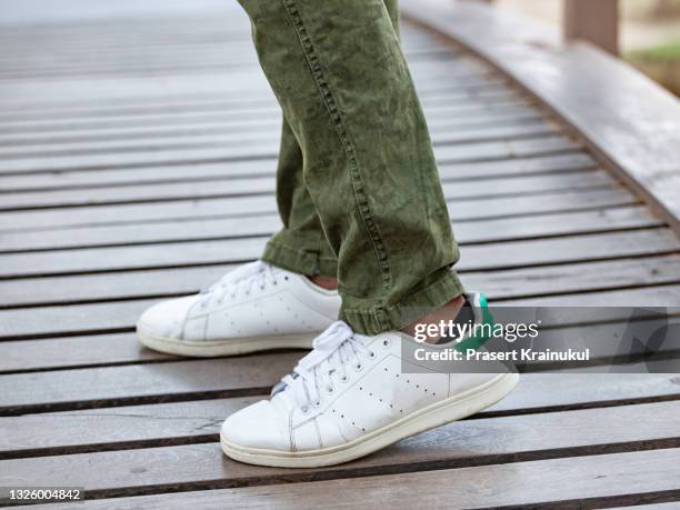 model wearing brown cargo pants or cargo trousers with white sneakers - chaussures blanches photos et images de collection