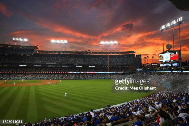 The sun sets over Dodger Stadium during the game between the Los Angeles Dodgers and the San Francisco Giants on June 28, 2021 in Los Angeles,...