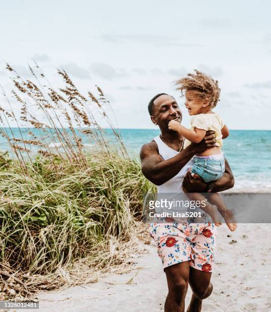 black father and mixed race daughter laugh together in the beach - beach florida family stockfoto's en -beelden