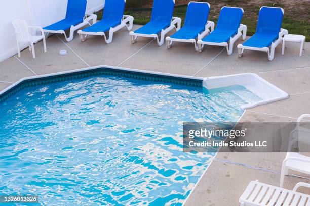 back yard pool at twilight with deck chairs and ripples - backyard deck stockfoto's en -beelden