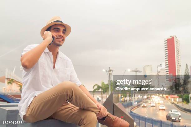 latin fit male using his cellphone / smartphone with 5g technology at guayaquil, ecuador - guayaquil stockfoto's en -beelden