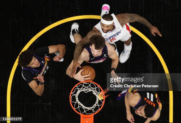Dario Saric of the Phoenix Suns grabs a rebound ahead of DeMarcus Cousins of the LA Clippers during the second half of game five of the Western...