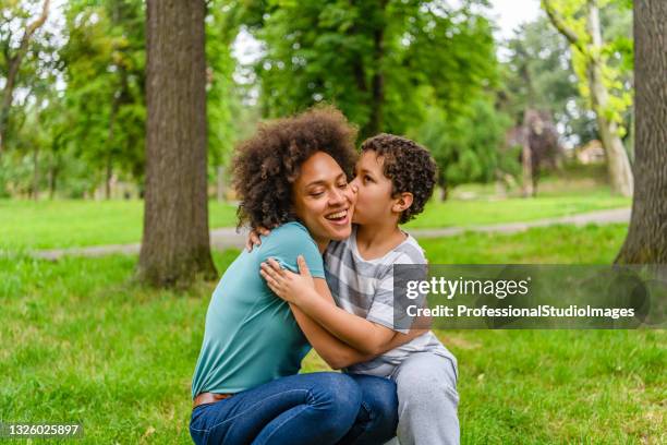 love emotions between african-american mother and son in public park. - international kissing day stock pictures, royalty-free photos & images