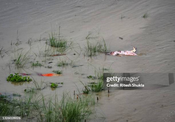 Bodies, many of which are believed to be COVID-19 victims, are seen partially exposed in shallow sand graves as rainwater inundated the site and...