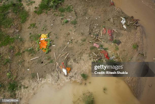 Bodies, many of which are believed to be COVID-19 victims, are seen partially exposed in shallow sand graves as rainwater inundated the site and...