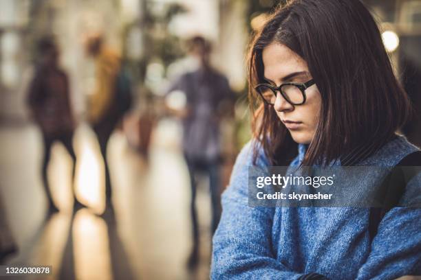 traurige high-school-schüler fühlen sich einsam in einem flur. - druck durch gleichaltrige stock-fotos und bilder