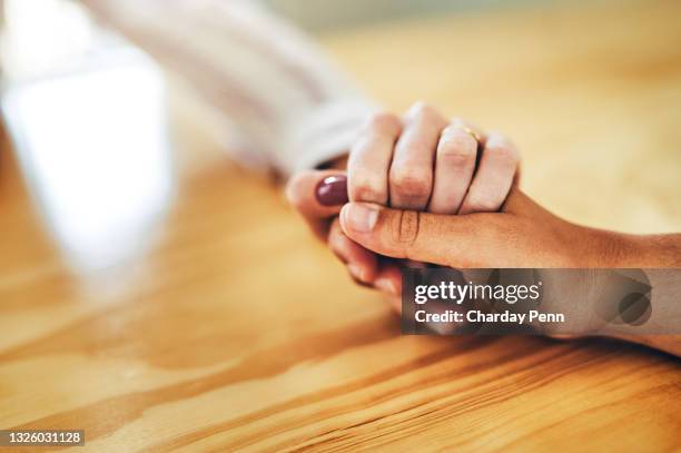 自宅で彼女の友人と一緒に座って、サポートで彼女の手を握っている認識できない女性のトリミングショット - mourning ストックフォトと画像