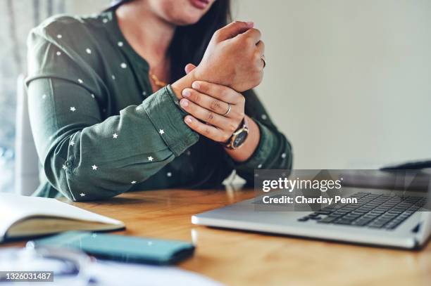 foto recortada de una empresaria irreconocible sentada sola en su oficina y sufriendo de dolor en la muñeca - hold wrists fotografías e imágenes de stock