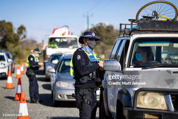 Member of the police force inspects cars at a Border Check Point on Indian Ocean Drive, north of Perth on June 29, 2021 in Perth, Australia. Lockdown...