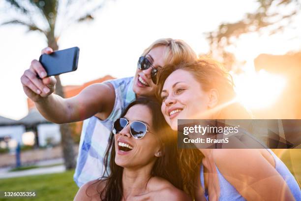 happy women taking a selfie with smart phone in nature. - s happy days stockfoto's en -beelden