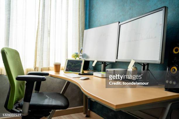 no people home office setups. the desk has a computer monitor and a tablet for stock investors. in the bedroom of the house. - computer monitor and keyboard stock pictures, royalty-free photos & images