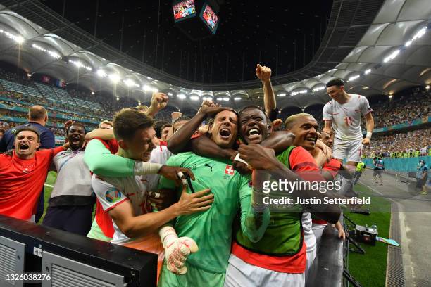 Yann Sommer and Denis Zakaria of Switzerland celebrate with team mates after their side's victory in the penalty shoot out after the UEFA Euro 2020...
