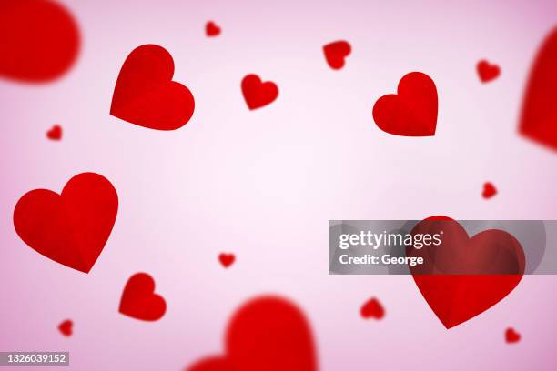 falling red hearts isolated on pink background - falling in love stock-fotos und bilder