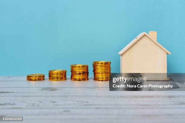 stacked of coins and house model - posición elevada fotografías e imágenes de stock