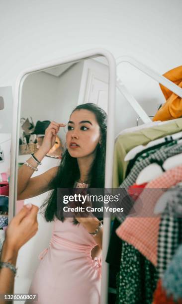 young latina applying makeup before going out - bedroom vanity stock pictures, royalty-free photos & images