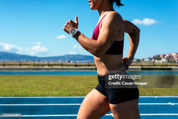 closeup of a young female sprinter training on an athletics track - thigh human leg stock pictures, royalty-free photos & images