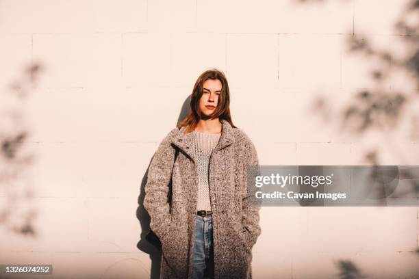 portrait of transgender woman standing against wall in city - autumn sadness stock pictures, royalty-free photos & images