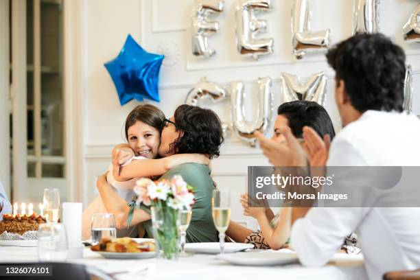 happy girl embracing grandmother at birthday party - wealthy family inside home stock pictures, royalty-free photos & images