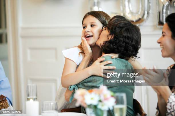 grandmother kissing girl during birthday party - grandma birthday ストックフォトと画像