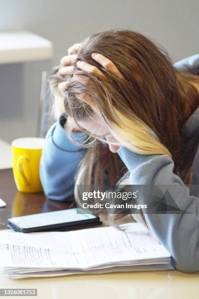 teen girl taking exam and studying at home - class argument ストックフォトと画像