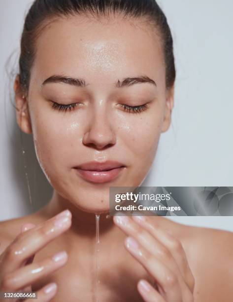 young beautiful woman with clean fresh skin with splash of water - white background - viso donna bellezza foto e immagini stock